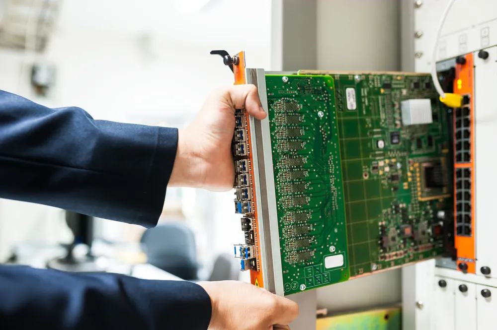 Engineer commissioning a network line card in a rack